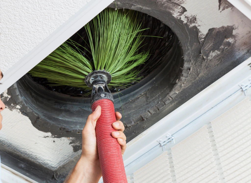 technician cleaning air duct