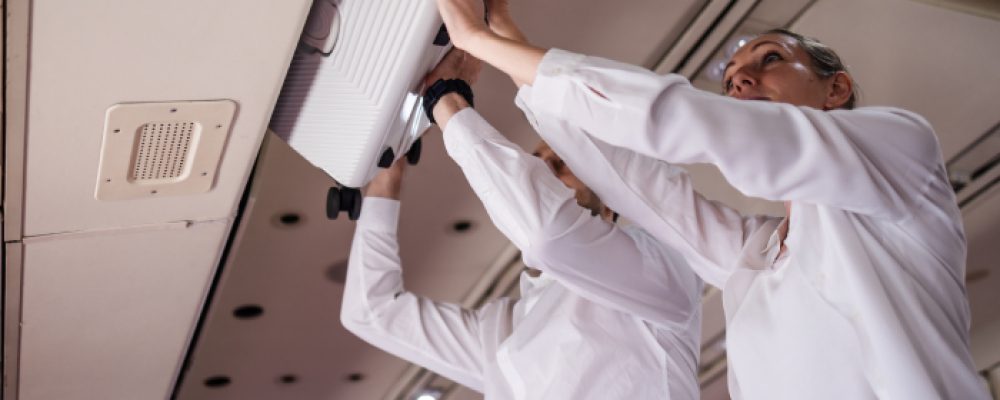 man-and-woman-storing-suitcase-in-overhead-compart-2026-01-07-06-09-56-utc (1)